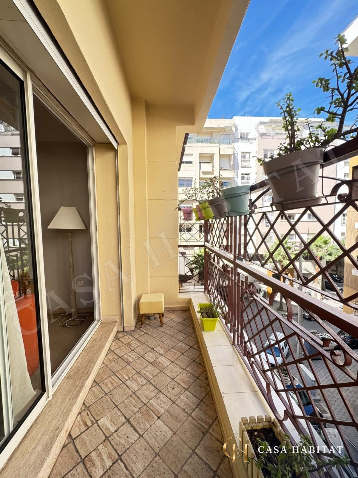 Balcon carrelé avec jardinières et garde-corps en fer forgé
