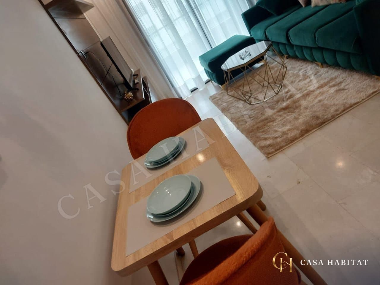 Table à manger en bois avec deux chaises orange et assiettes bleues