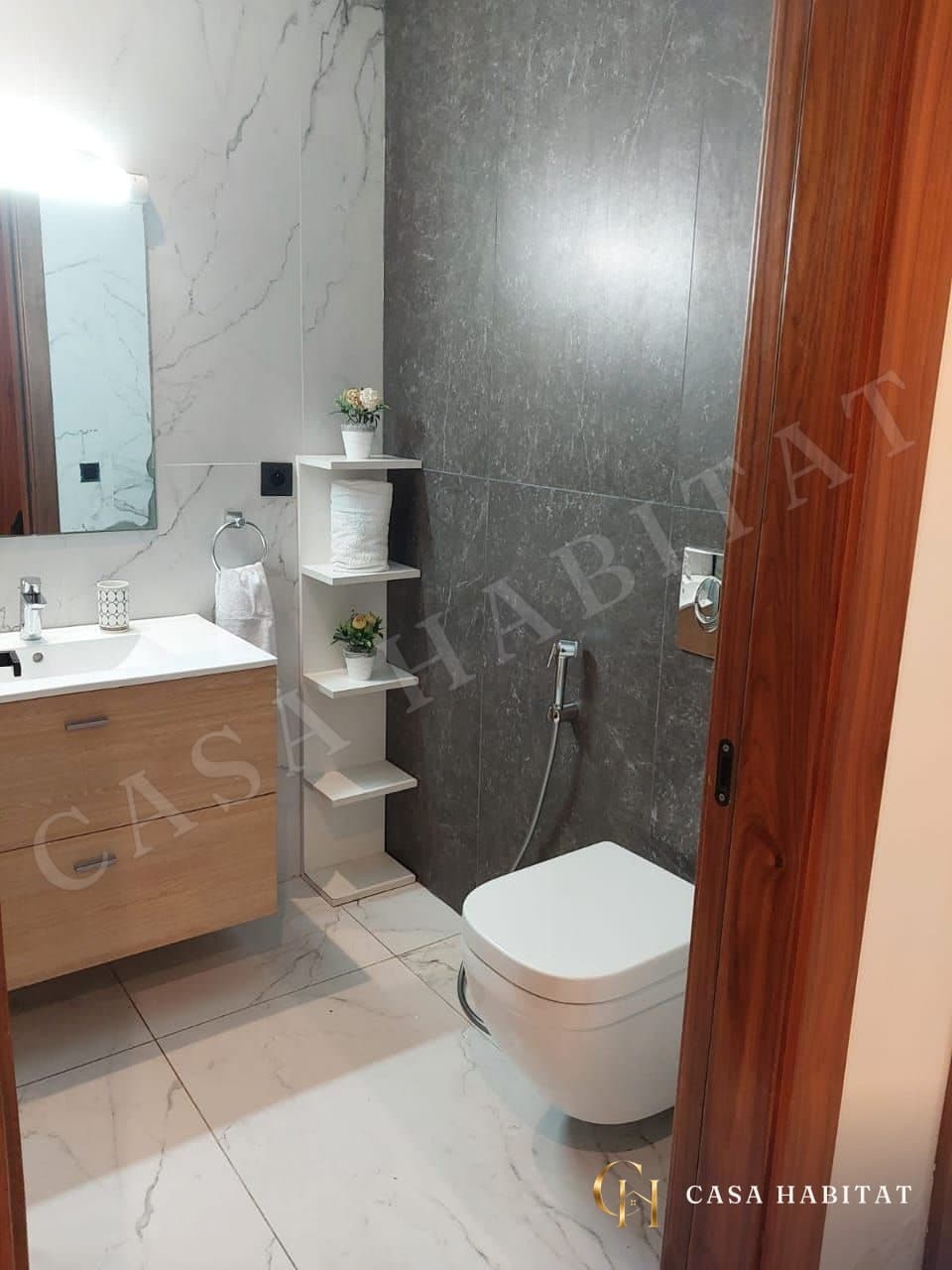 Salle de bain avec meuble vasque en bois et douche à main