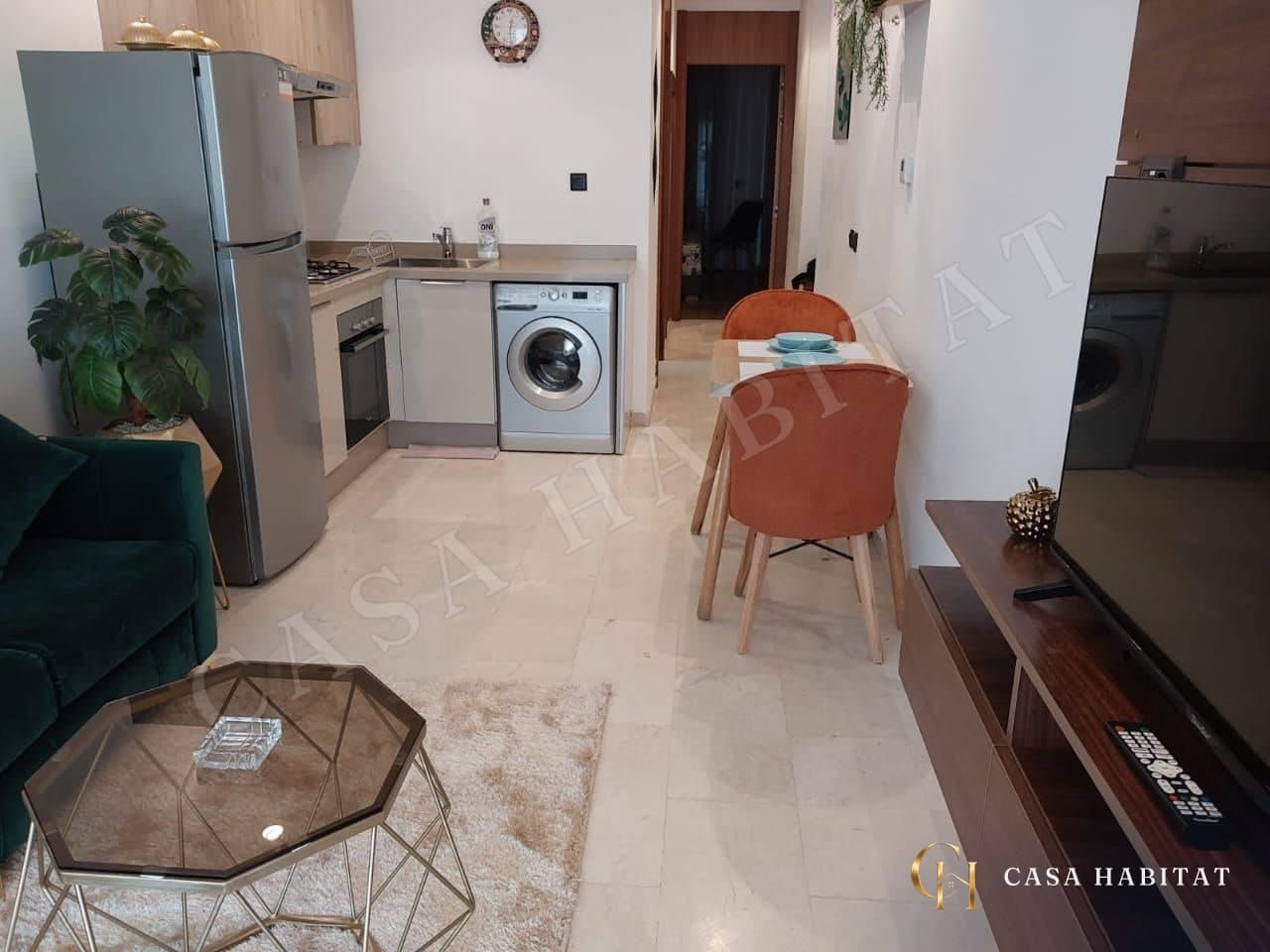Cuisine ouverte avec lave-linge, four et table à manger