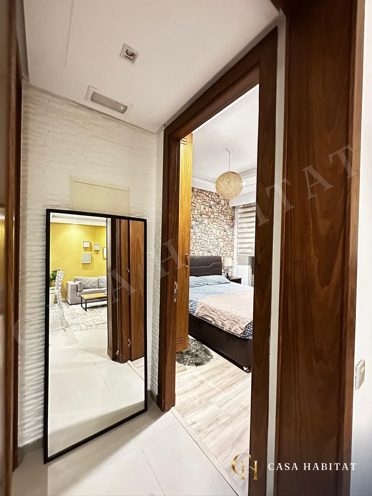 Couloir avec miroir menant à une chambre en pierre