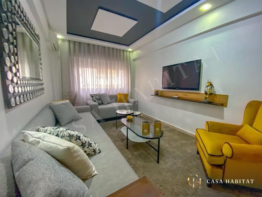 Living room with gray sofa, yellow armchair and wall-mounted TV