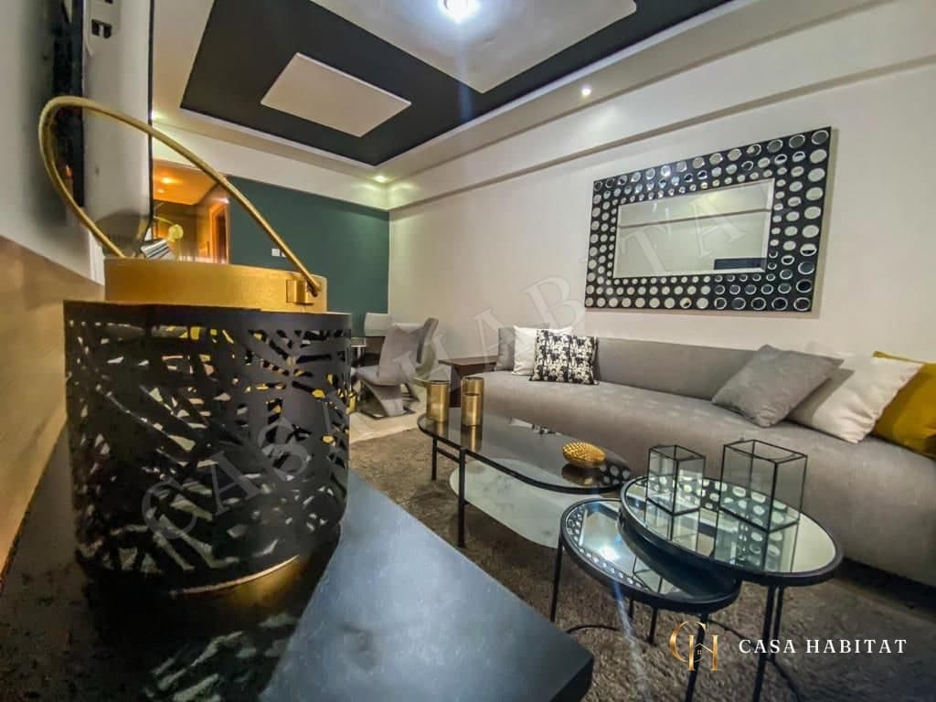 Salon avec miroir à motifs noirs et tables gigognes en verre