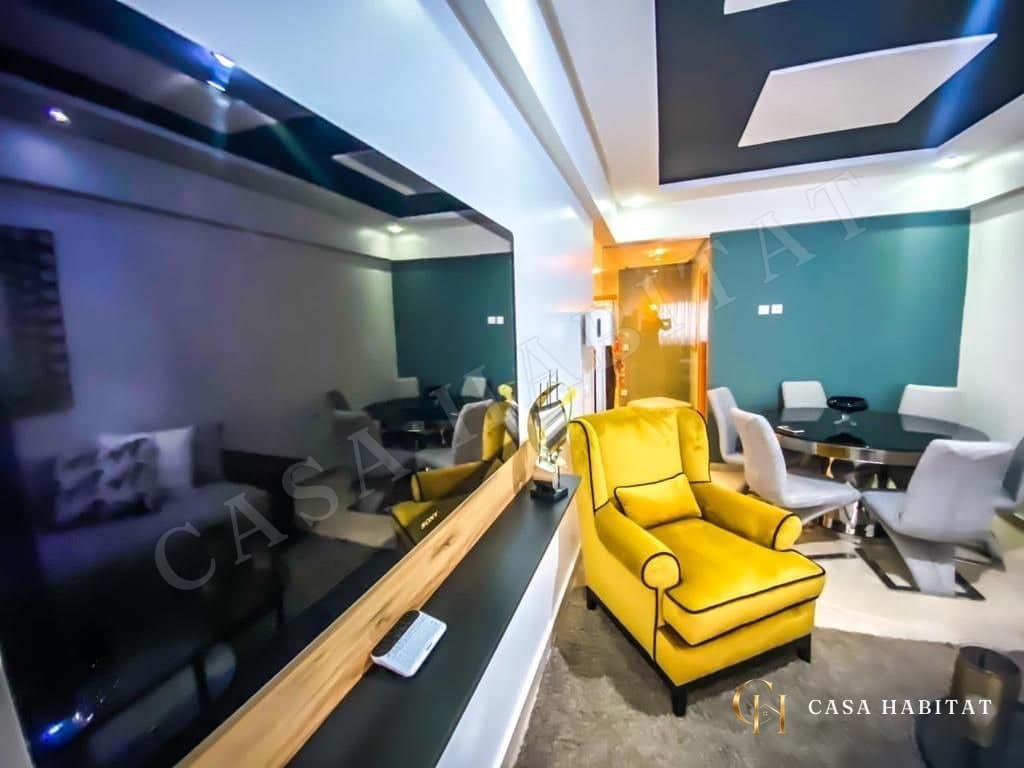 Salon ouvert sur coin repas avec fauteuil jaune et table ronde