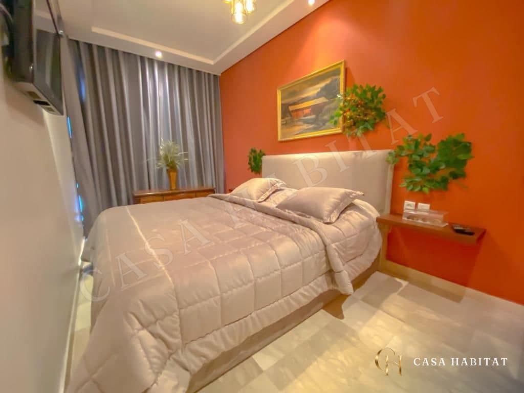Chambre avec mur orange, lit blanc et plantes murales
