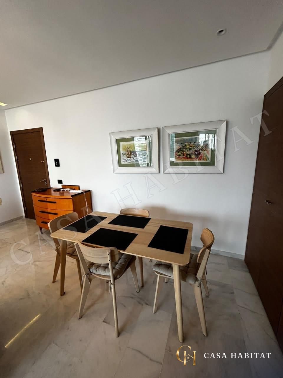 Salle à manger avec table en bois et chaises, cadres au mur