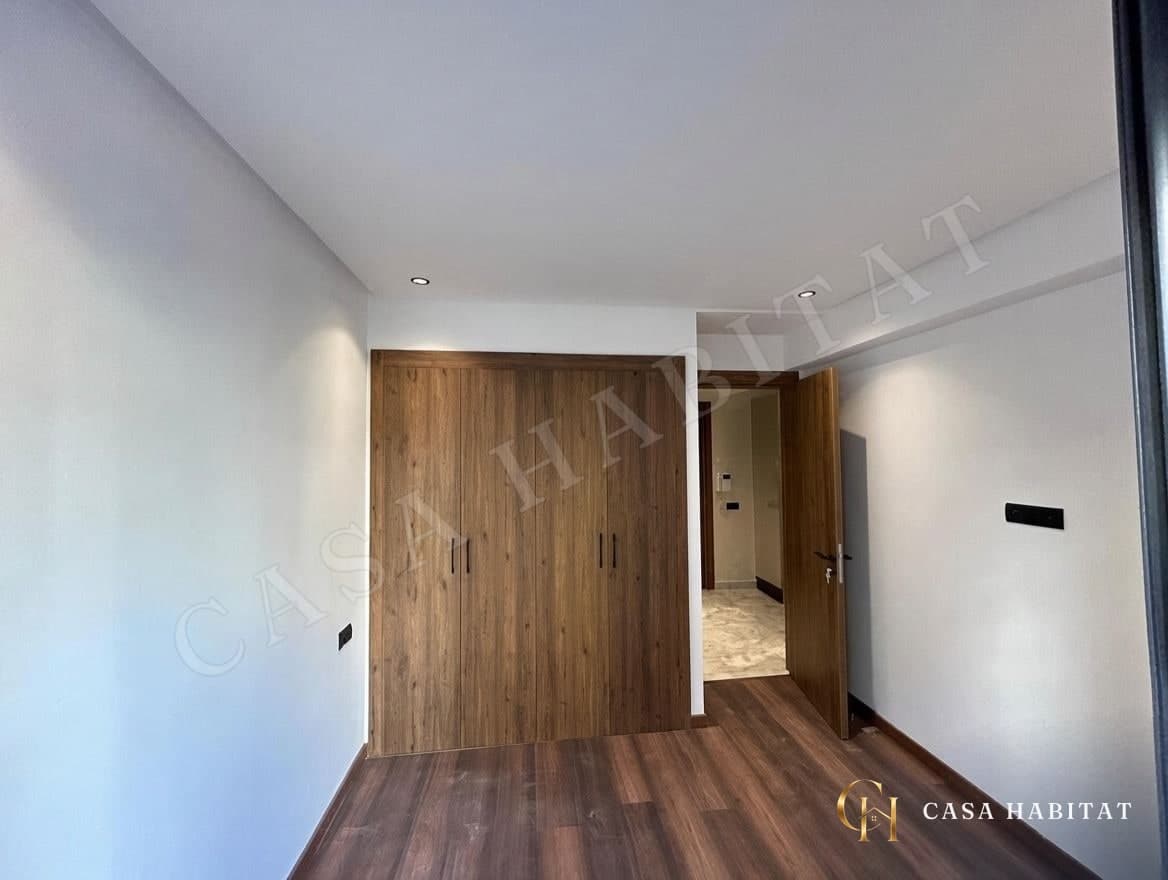 Chambre avec placard en bois et sol en parquet stratifié