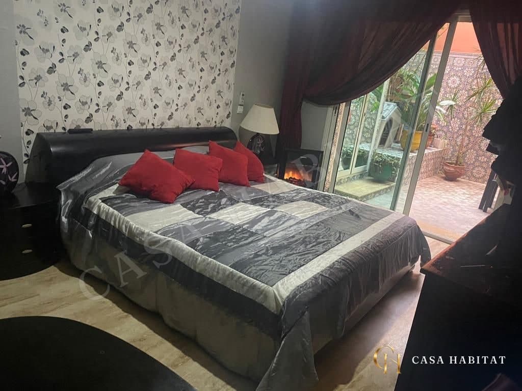 Chambre avec lit à coussins rouges et accès à une terrasse carrelée