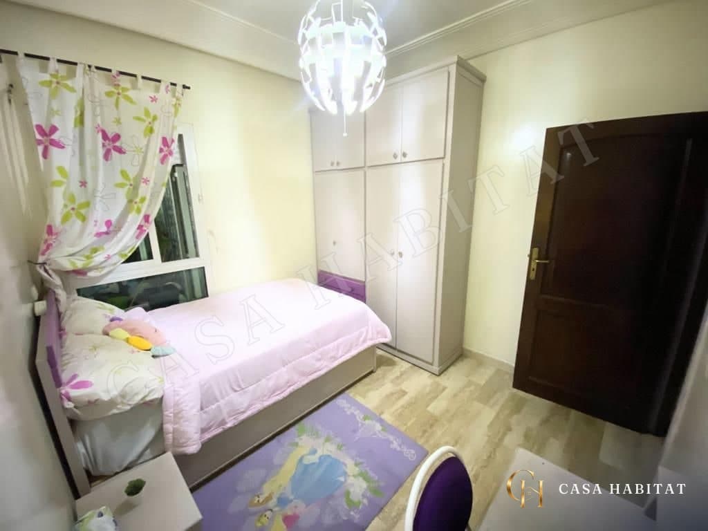 Chambre d'enfant avec lit, armoire blanche et tapis violet
