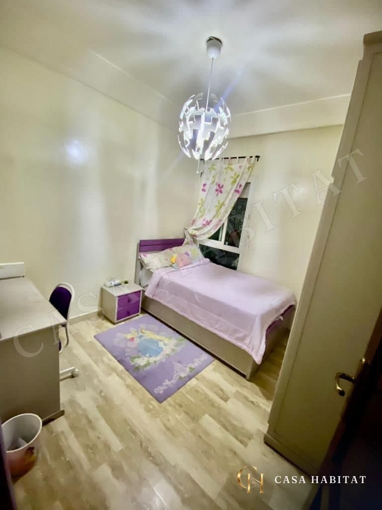 Chambre d'enfant avec lit, bureau blanc et armoire blanche