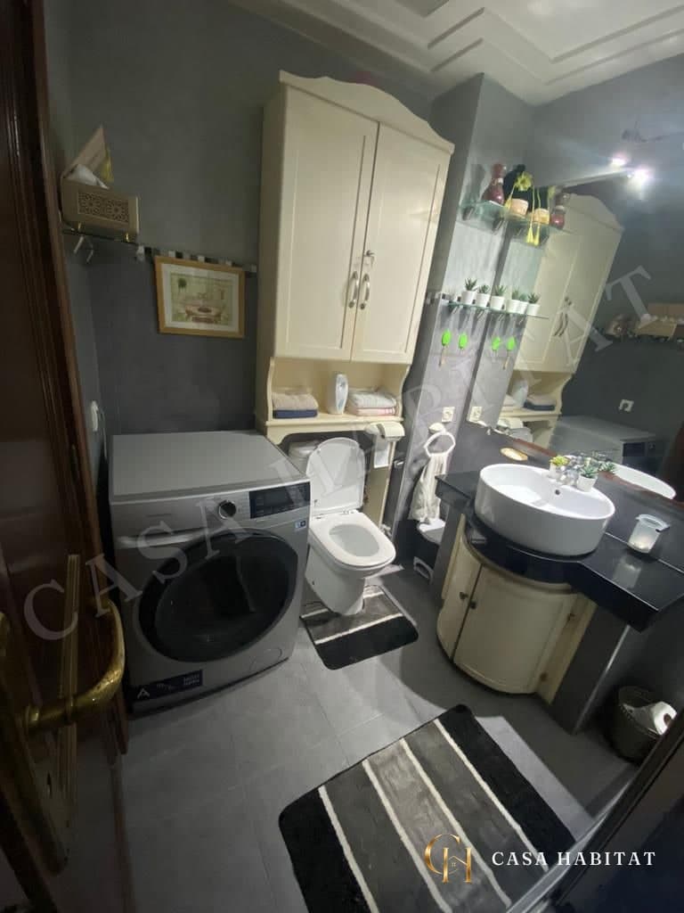 Salle de bain avec lave-linge, WC et vasque sur meuble