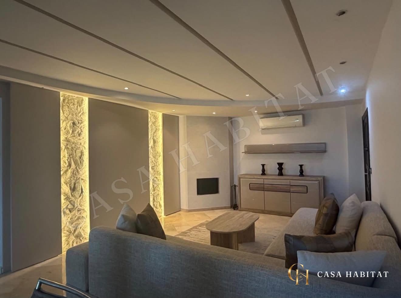 Salon avec canapé gris, table basse et murs éclairés par LED