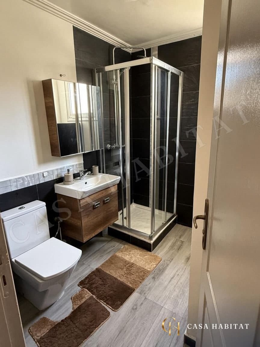 Salle de douche avec cabine vitrée et meuble vasque