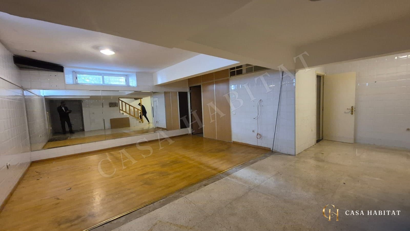 Salle de sport en parquet, miroirs muraux et portes en bois