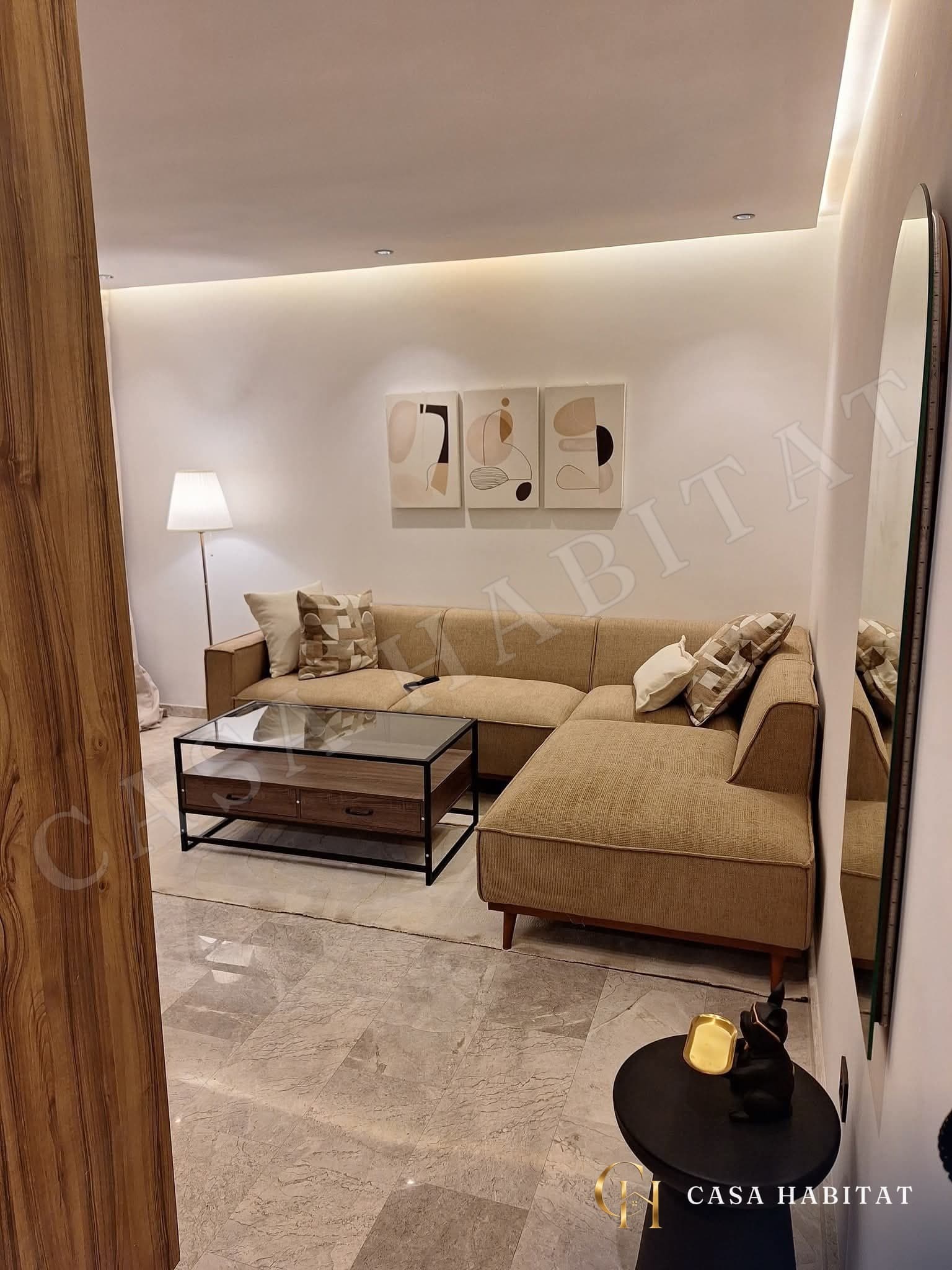 Salon avec canapé beige et miroir mural