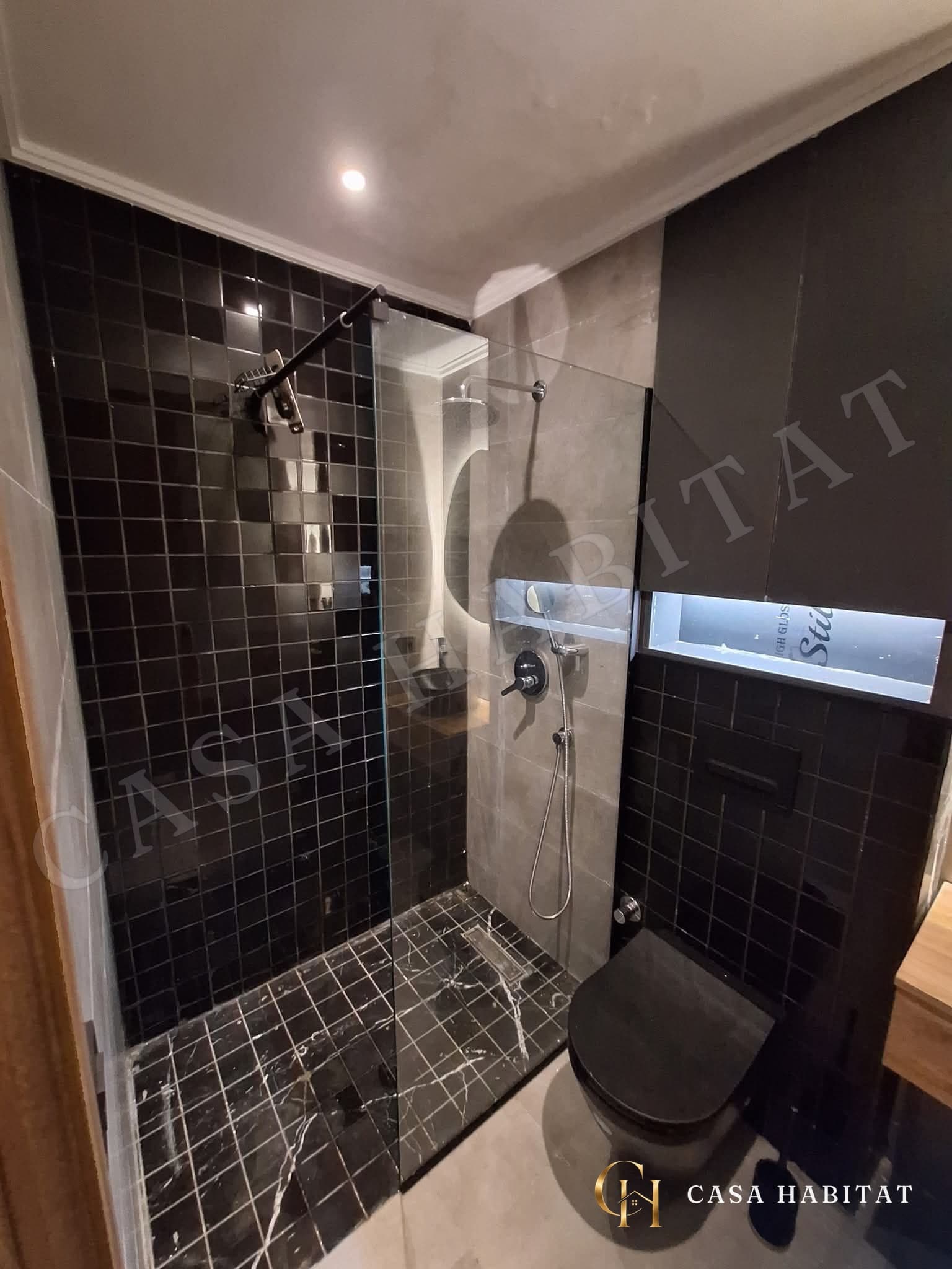 Douche carrelée noir et gris avec WC suspendu