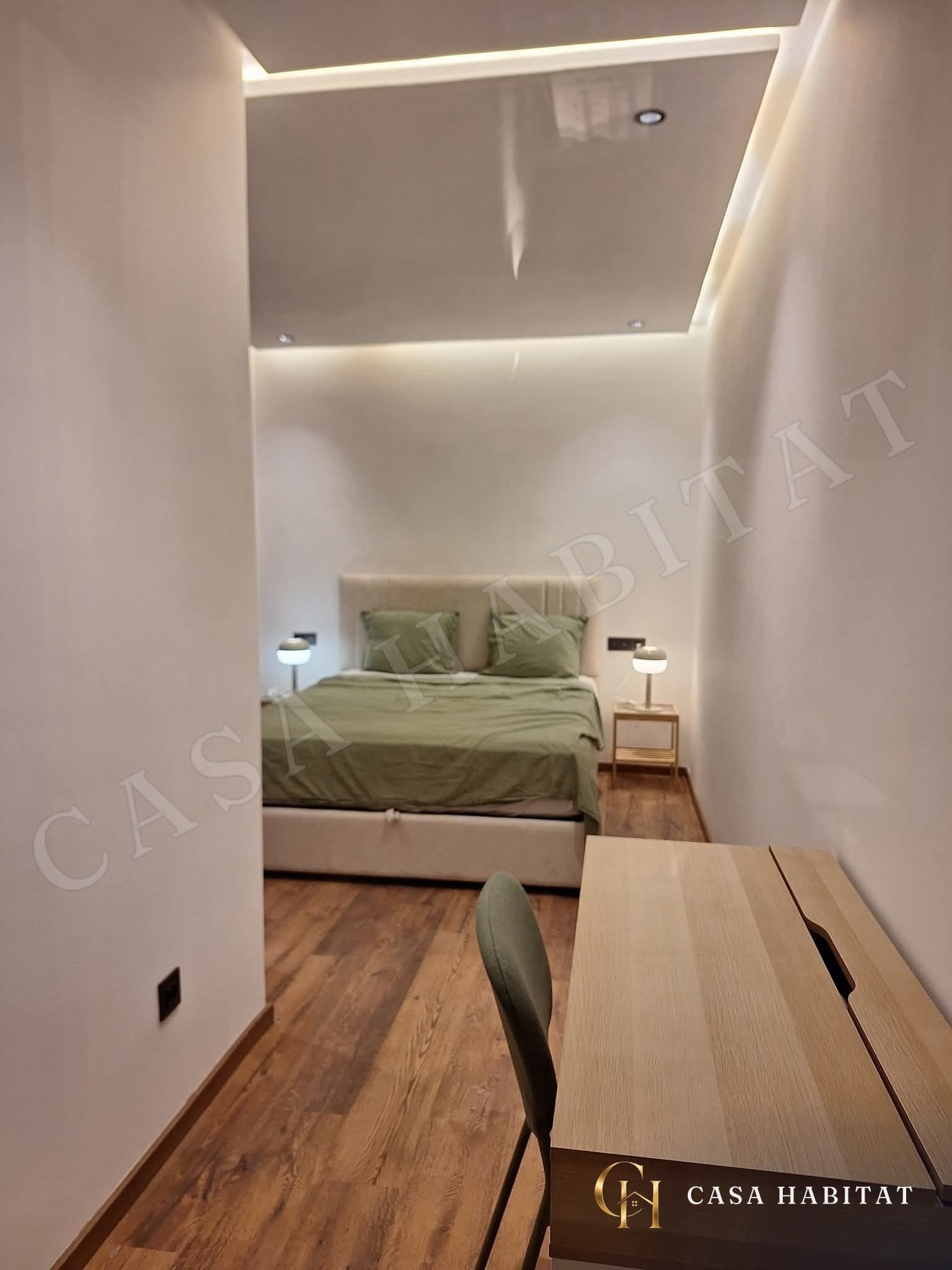 Chambre avec lit vert et bureau en bois