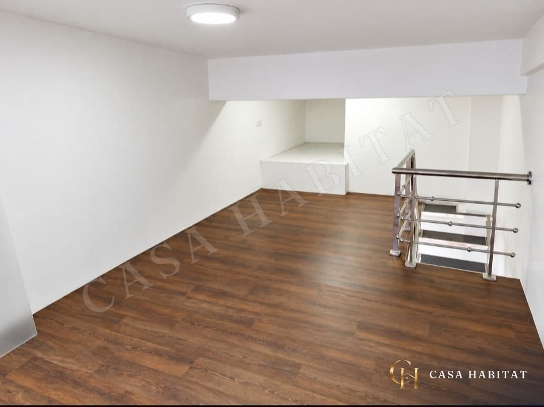 Entresuelo vacío con suelo laminado y barandilla de acero inoxidable